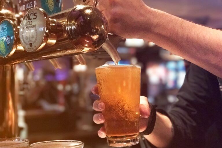pub, com torneiras de cervejas e uma pessoa se servindo