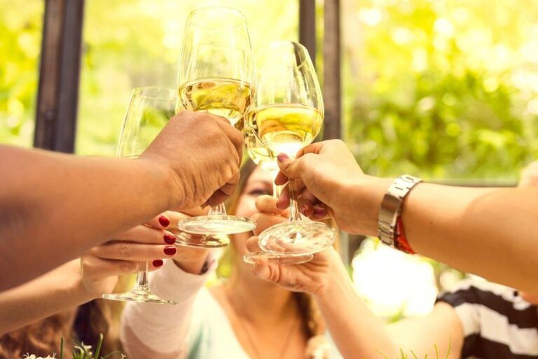 Pessoas brindando com vinho branco