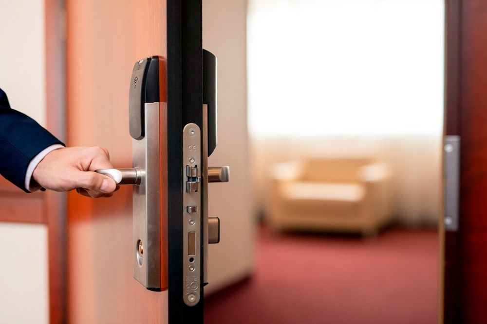 homem abrindo a porta de um hotel