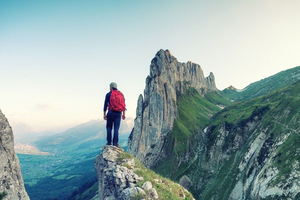 Homem no alto de uma montanha de pedra.