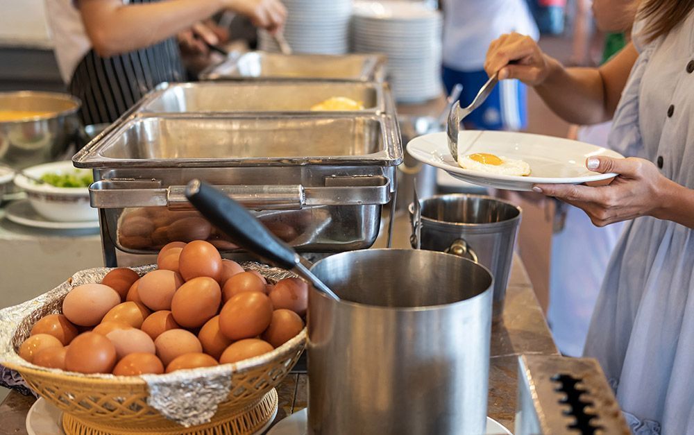 Pessoas tomam café da manhã buffet no hotel
