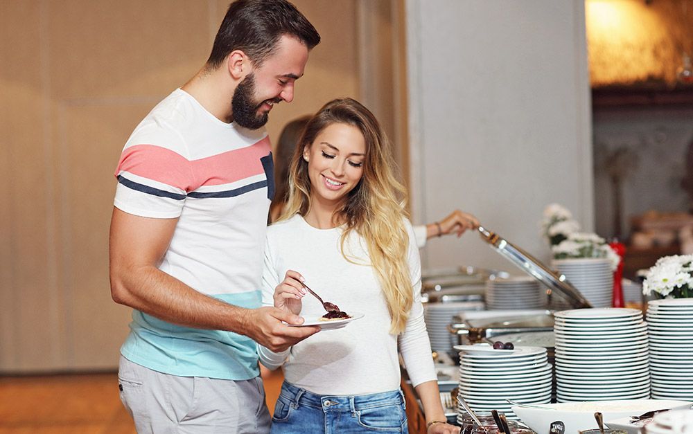 Homem e mulher pegando comida em hotel
