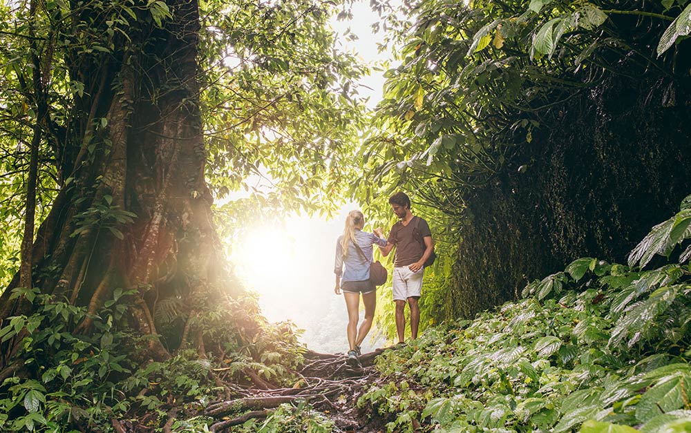 Casal de férias fazendo trilha na natureza